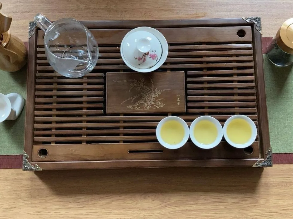 Chinese tea ceremony with a wooden tea tray and porcelain cups